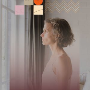 Middle-aged woman with graying hair looking out a window, appearing thoughtful.