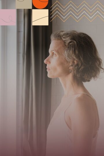 Middle-aged woman with graying hair looking out a window, appearing thoughtful.