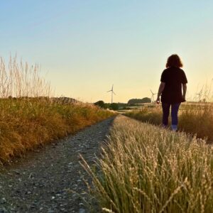 Woman walking in a field of wheat.
