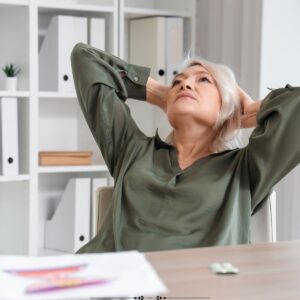 image of mature woman taking a break at her desk.
