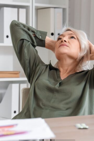 image of mature woman taking a break at her desk.