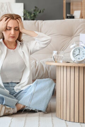 Image of overwhelmed woman sitting on the floor.