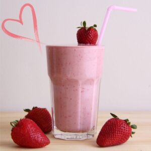 Image of a protein shake in a glass decorated with strawberries.