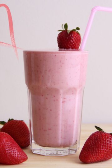 Image of a protein shake in a glass decorated with strawberries.