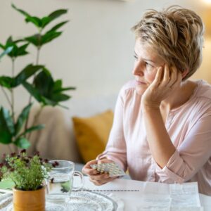 Woman sitting at a table, thinking.