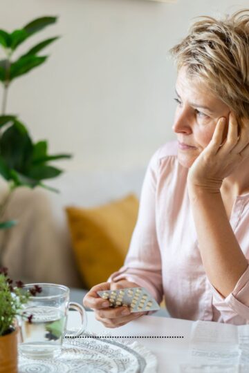 Woman sitting at a table, thinking.