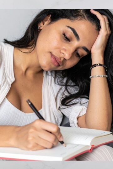 woman writing in a journal.