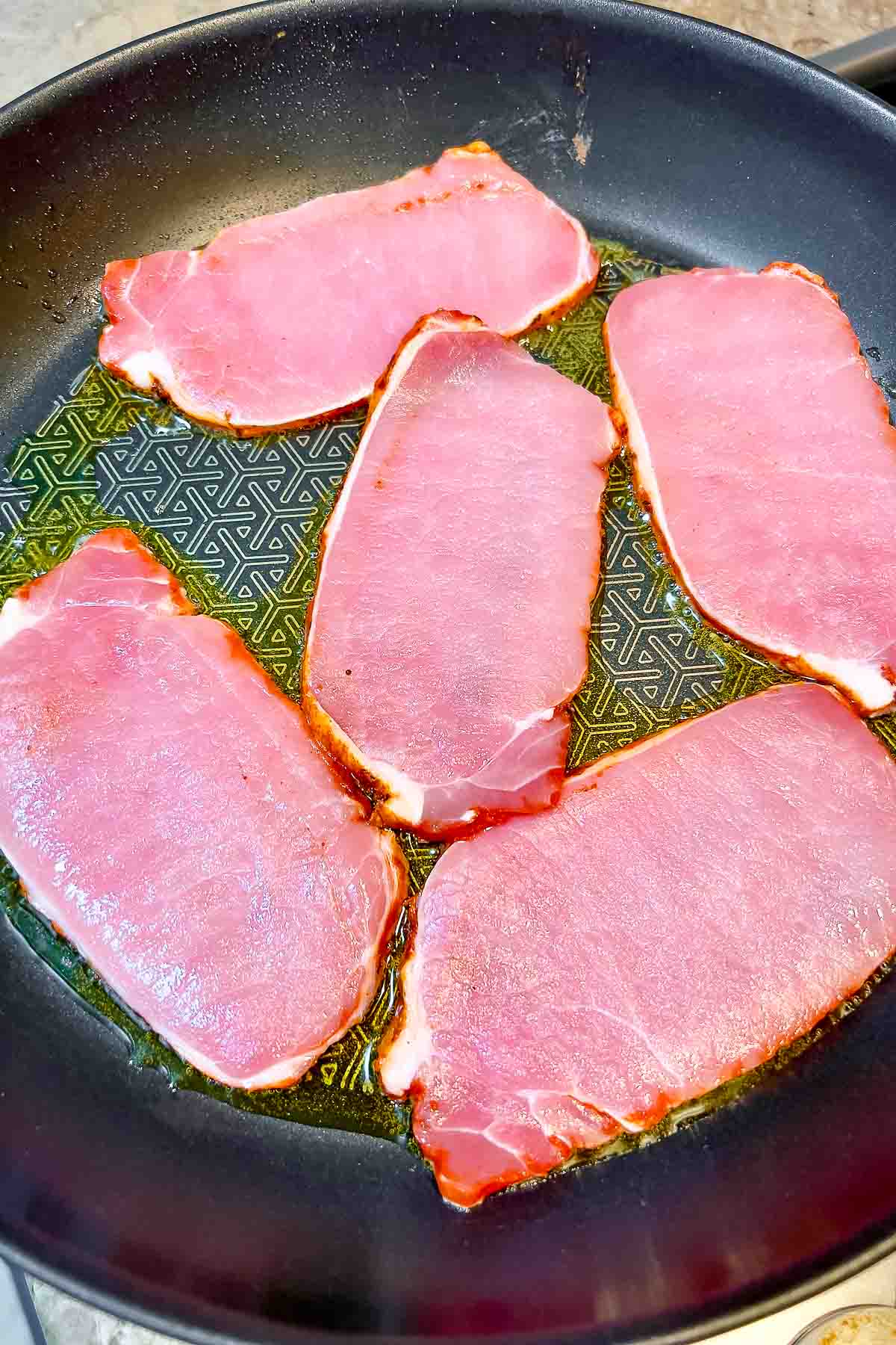 pork loin in adobo(lomo adobado) slices cooking in a pan.